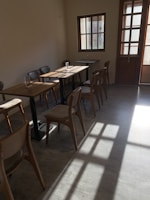 Warm sunlight streaming through the cafe windows onto rustic wooden tables.