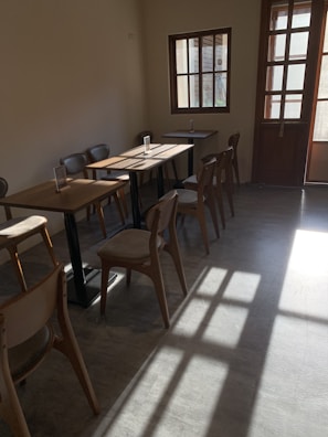 Warm sunlight streaming through the cafe windows onto rustic wooden tables.