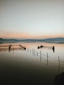 A serene river scene with fishing nets and boats at dawn.
