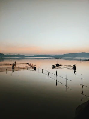 A serene river scene with fishing nets and boats at dawn.
