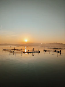A vibrant coastal scene showing Indian fishermen working together on traditional boats at sunrise.