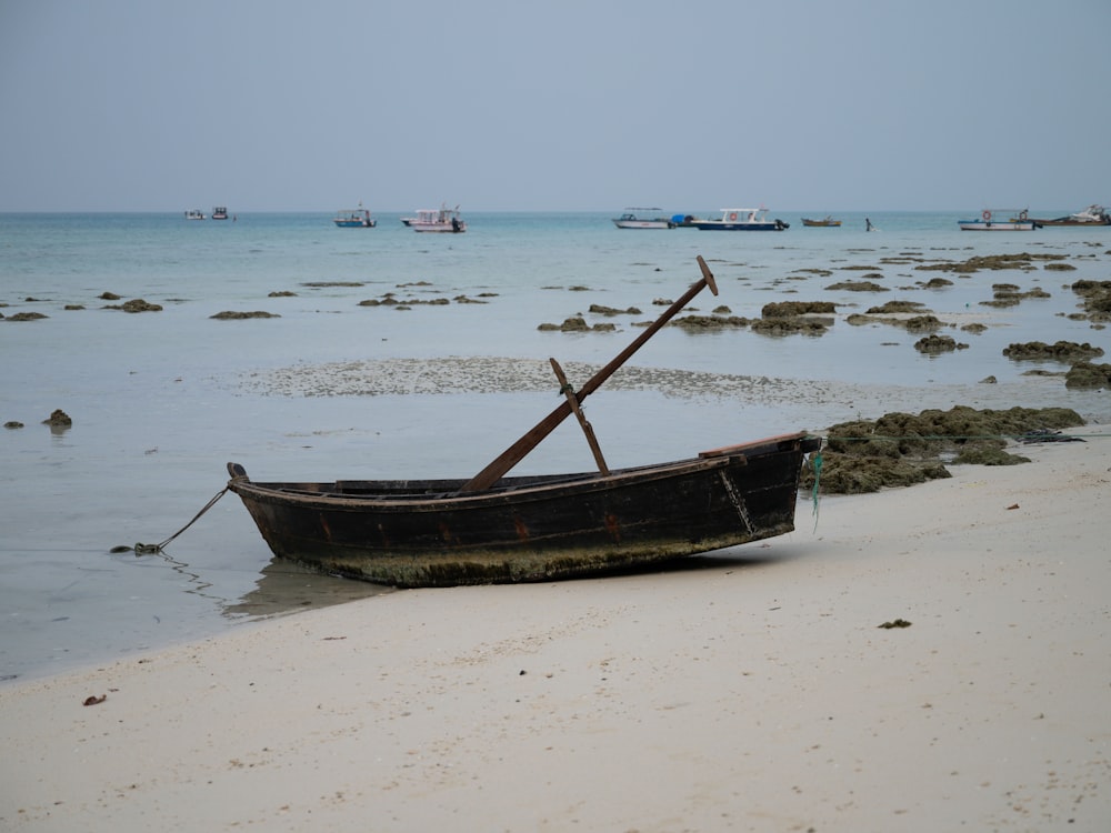 a boat sitting on top of a sandy beach