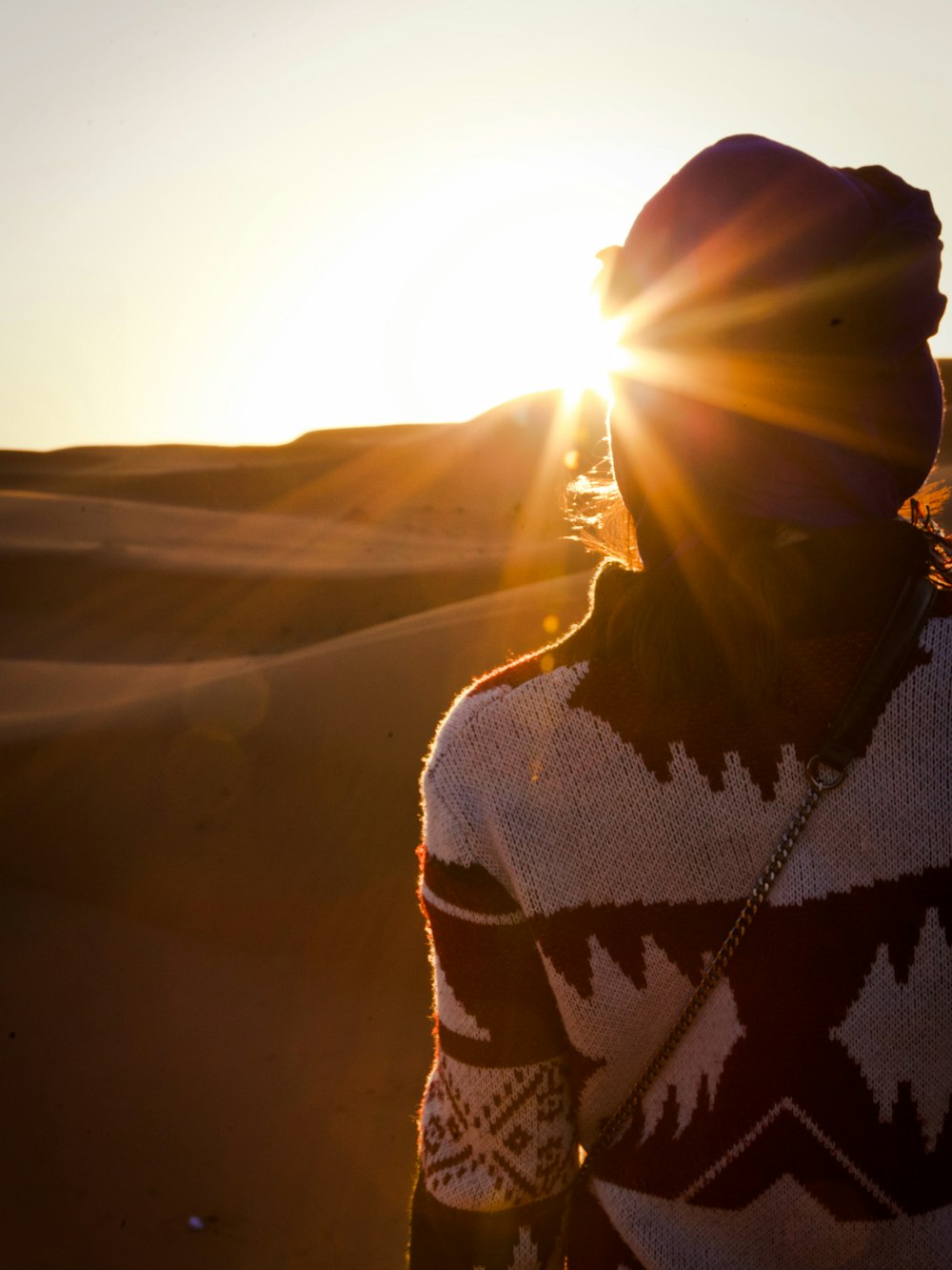 a person standing in the desert at sunset