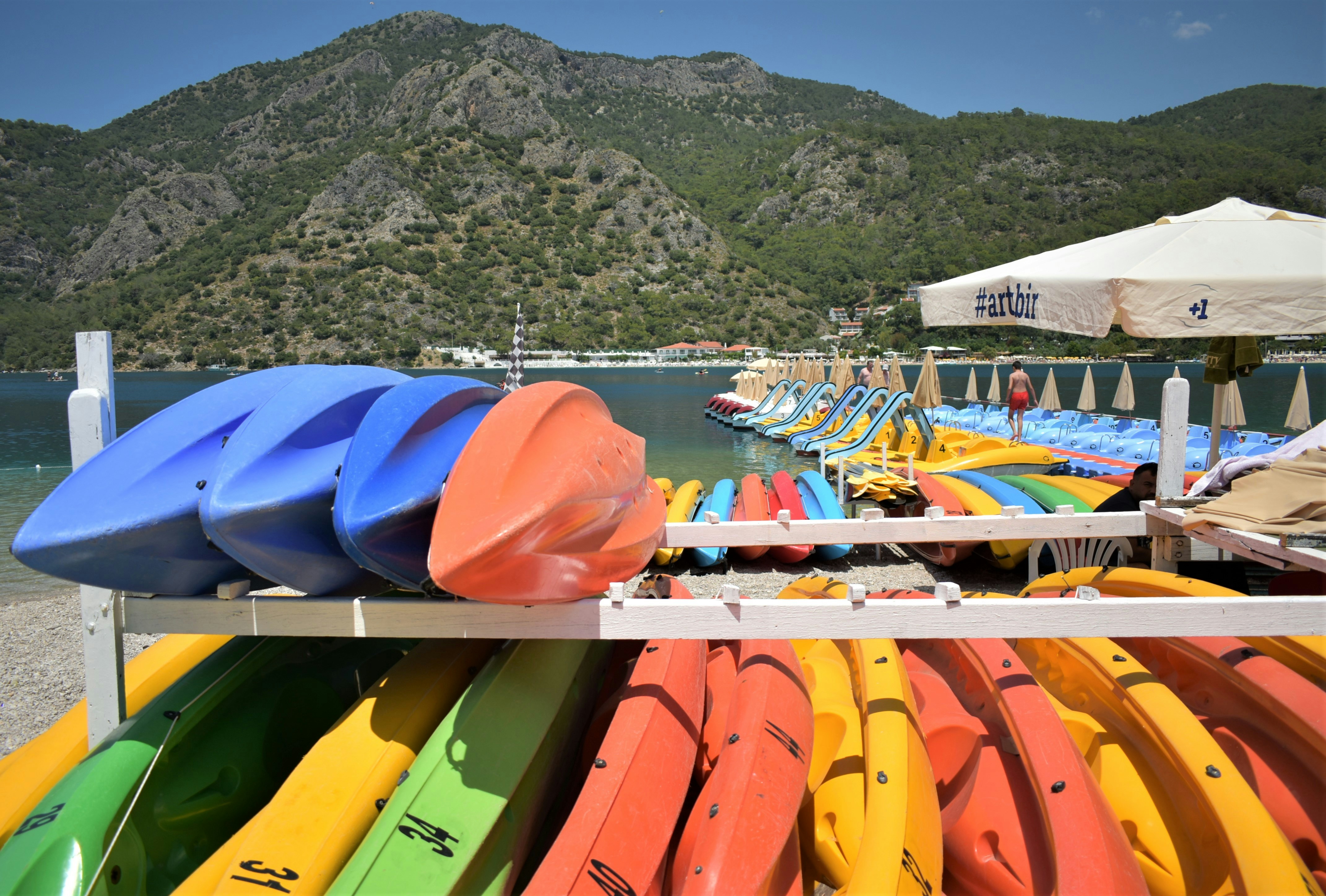 a bunch of kayaks are lined up on a rack, 