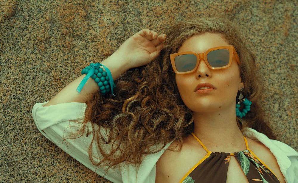 a woman laying on the ground wearing sunglasses