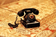 an old fashioned telephone sitting on top of a bed