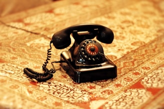 an old fashioned telephone sitting on top of a bed