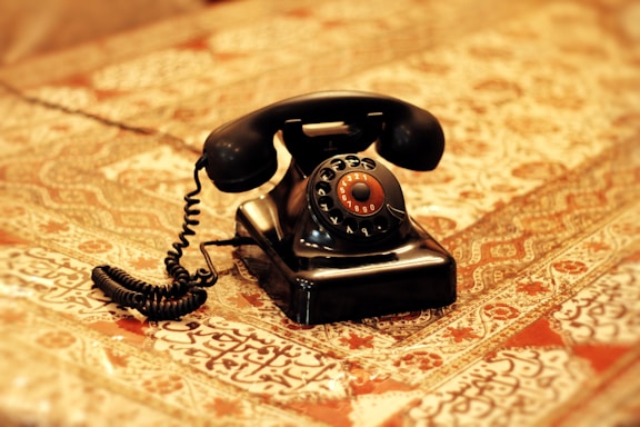 an old fashioned telephone sitting on top of a bed
