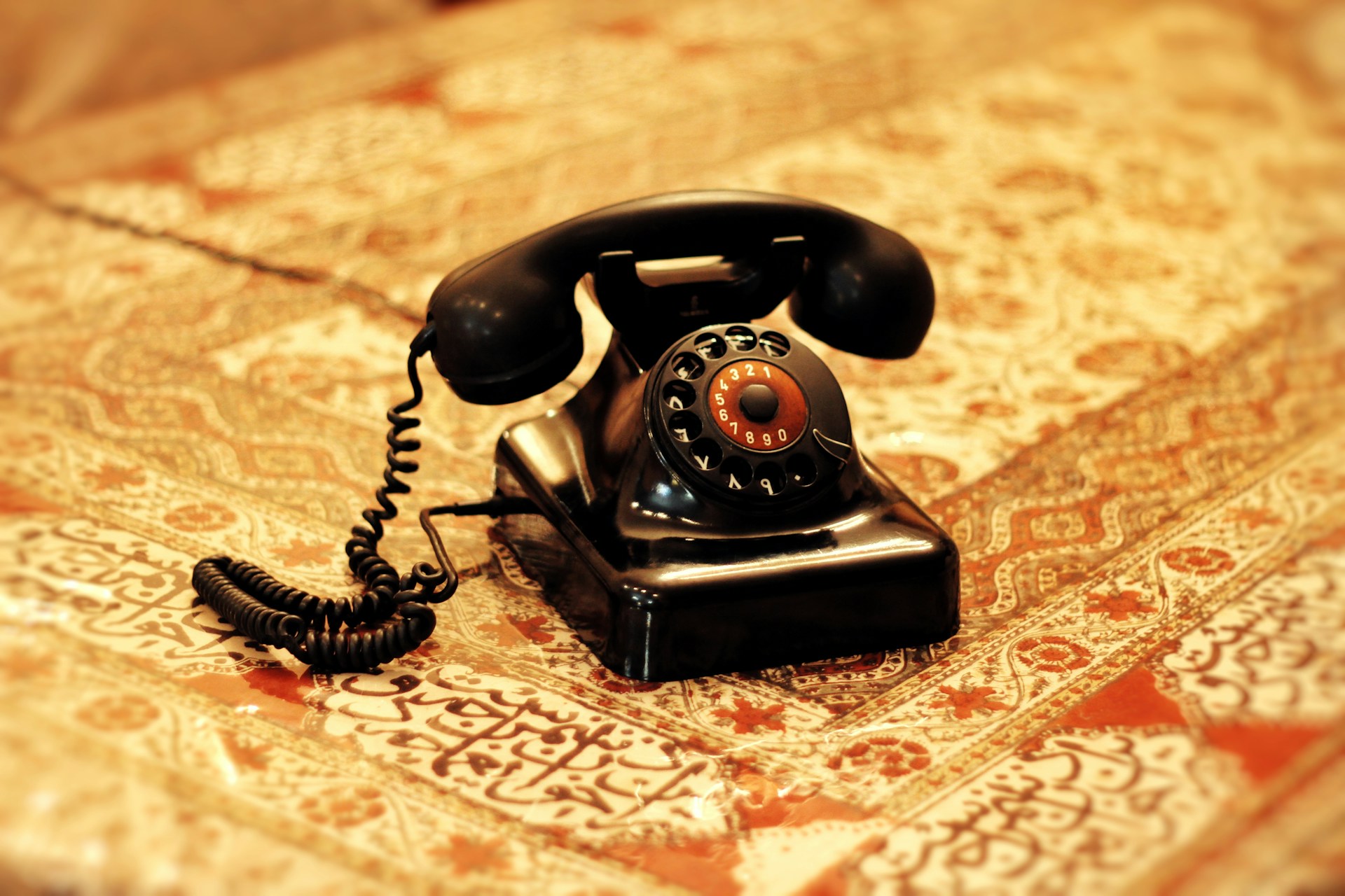 an old fashioned telephone sitting on top of a bed