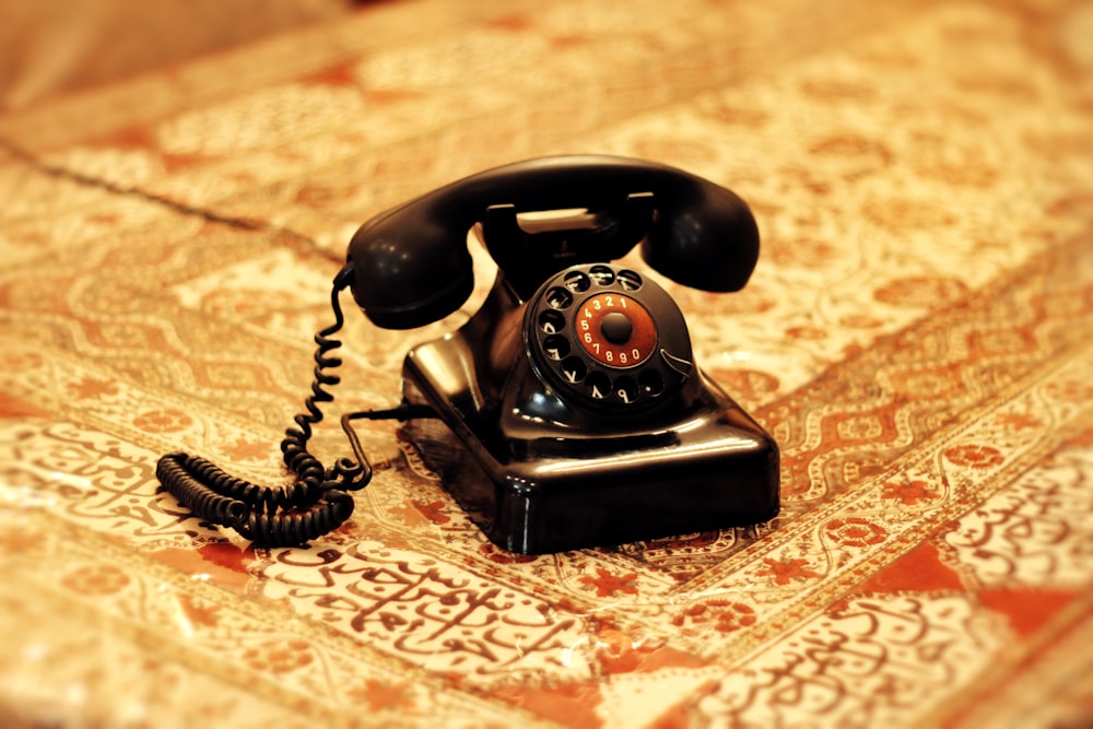 an old fashioned telephone sitting on top of a bed