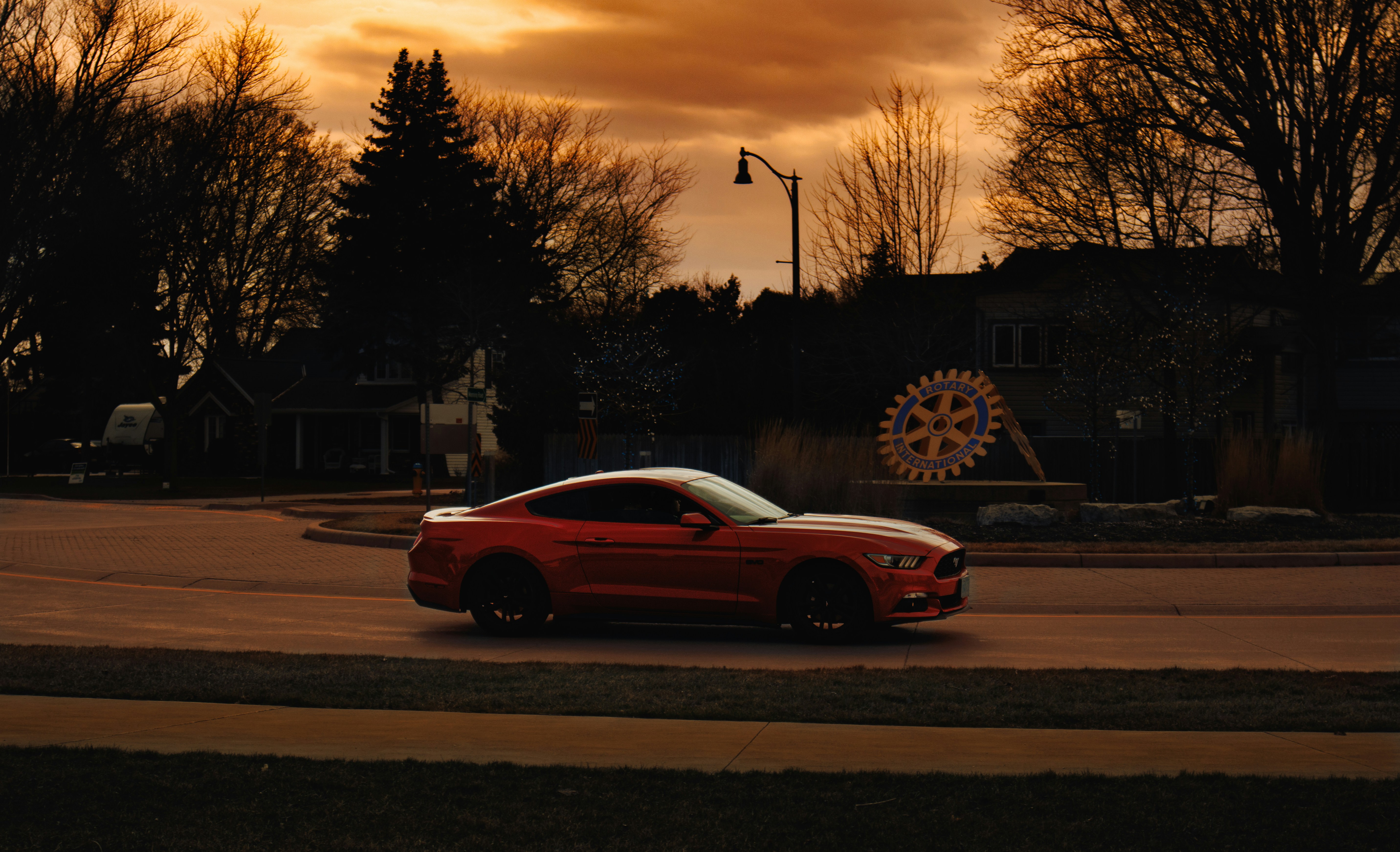 Un coche deportivo rojo conduciendo por una calle