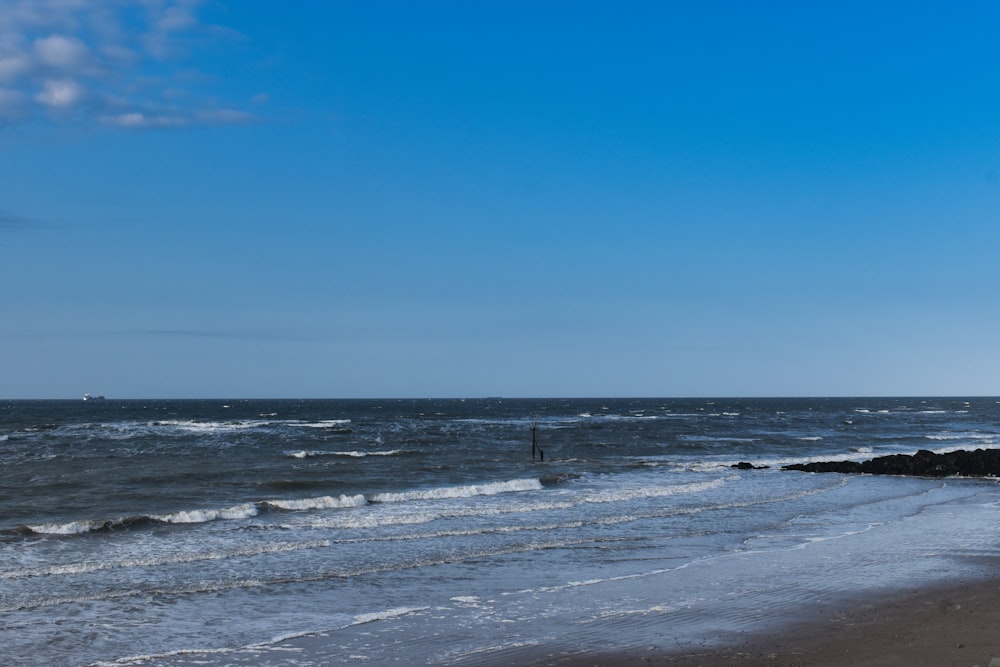 a sandy beach with waves coming in to shore