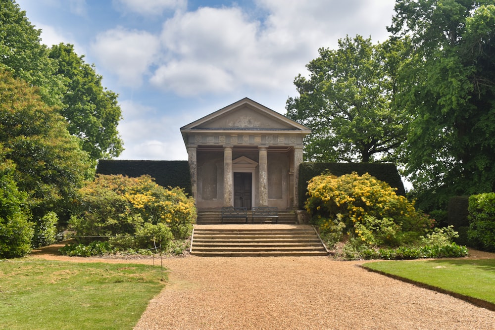 a small building sitting in the middle of a lush green park