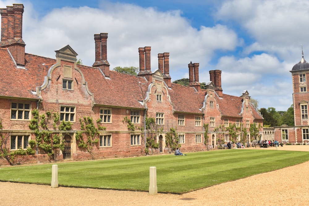 a large brick building with a lawn in front of it