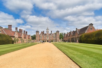 a dirt road leading to a large building