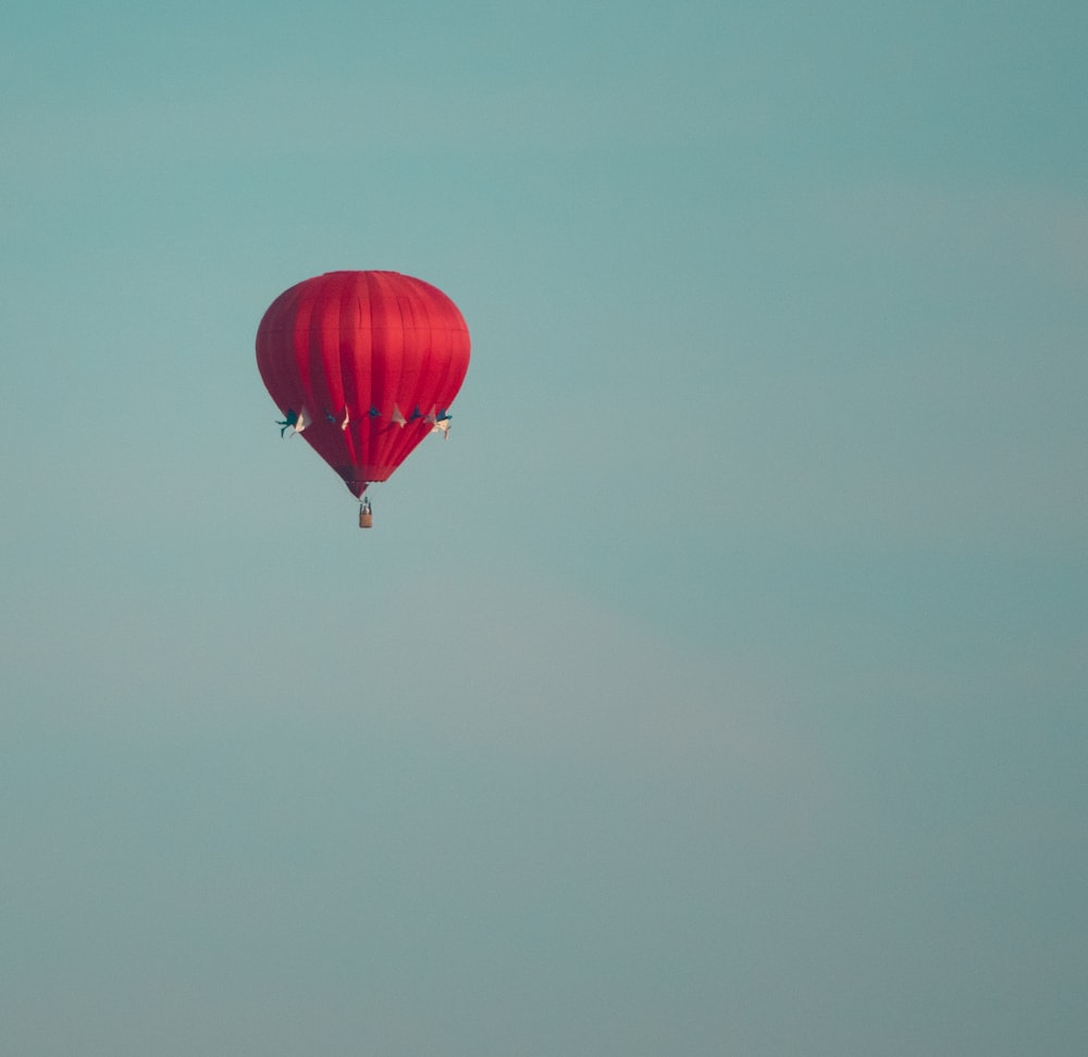 a red hot air balloon flying in the sky