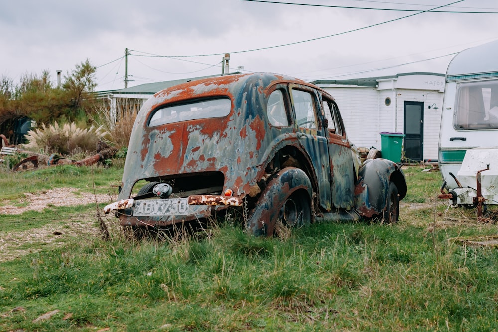 an old rusted out truck sitting in a field