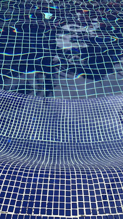 a blue tiled swimming pool with blue tiles