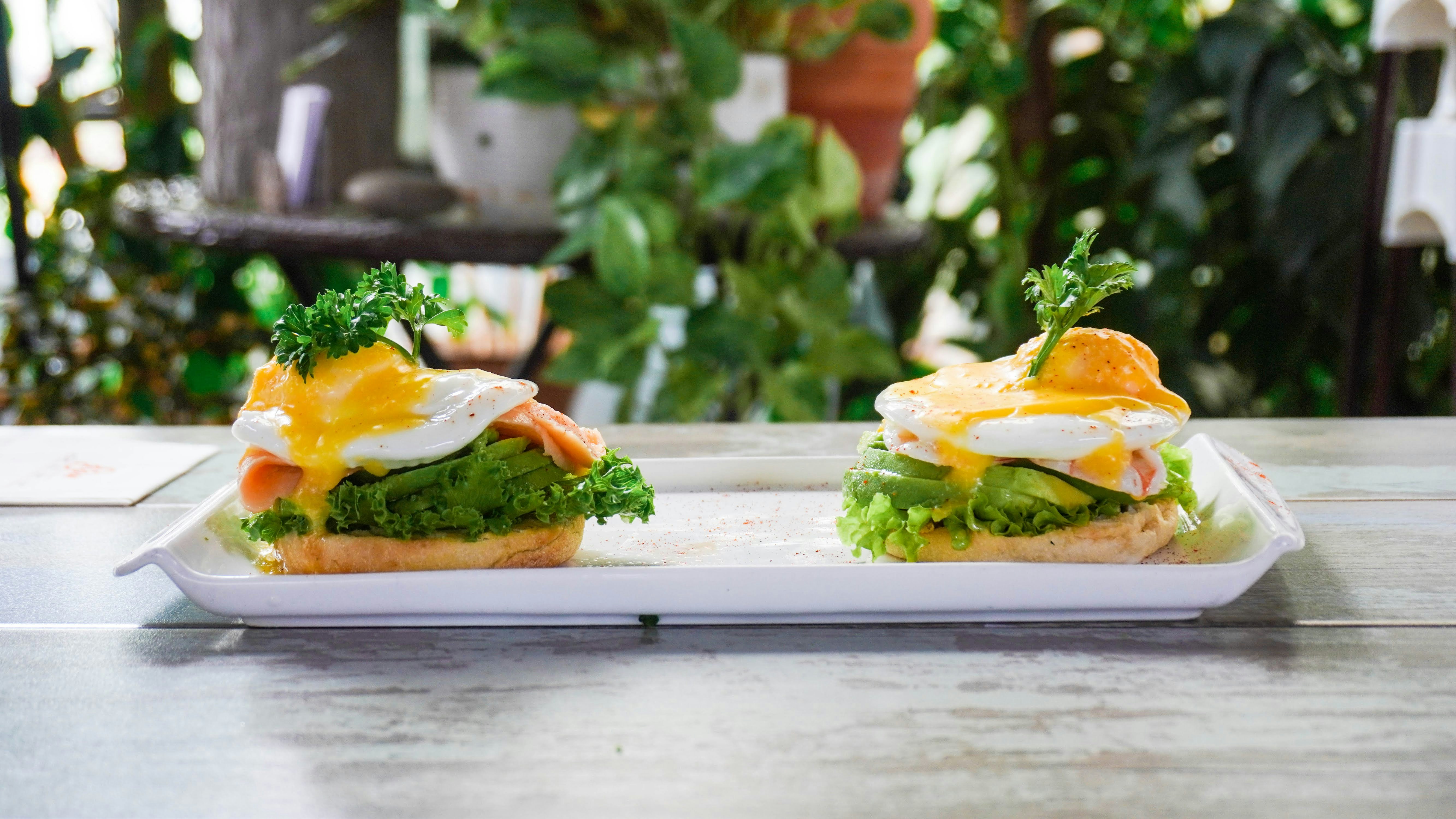 a white plate topped with two sandwiches covered in lettuce