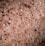 A close-up view of coarse pink salt crystals, varying in size and texture, with a subtle shimmer effect.