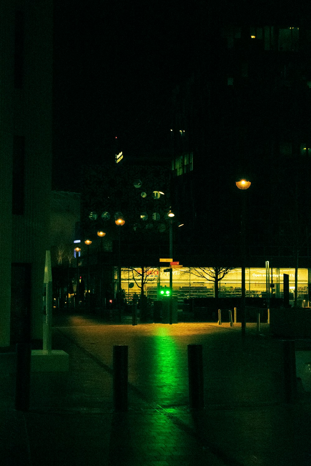 a dark city street at night with a green traffic light