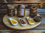 a wooden tray topped with jars filled with different types of condiments