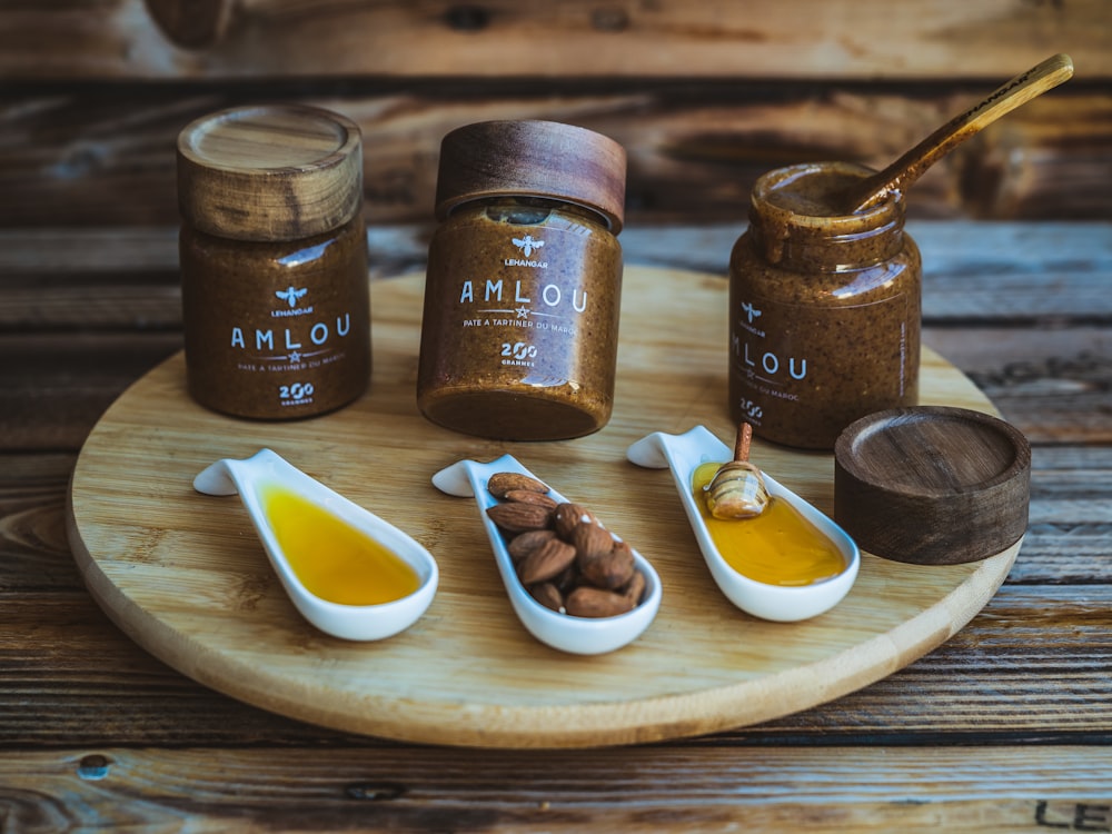 a wooden tray topped with jars filled with different types of condiments