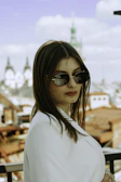 Side profile of a woman wearing Wild sunglasses with city skyline blurred behind.