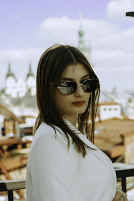 Side profile of a woman wearing Wild sunglasses with city skyline blurred behind.