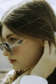 a woman wearing glasses and a white shirt