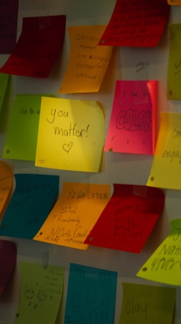 An overhead shot of colorful sticky notes arranged neatly on a desk, each with motivational words.