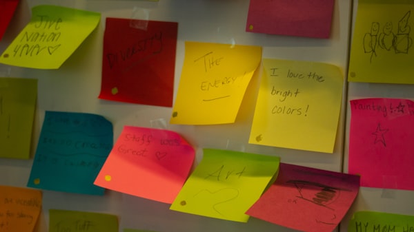 Kleurrijke sticky notes op een wand.