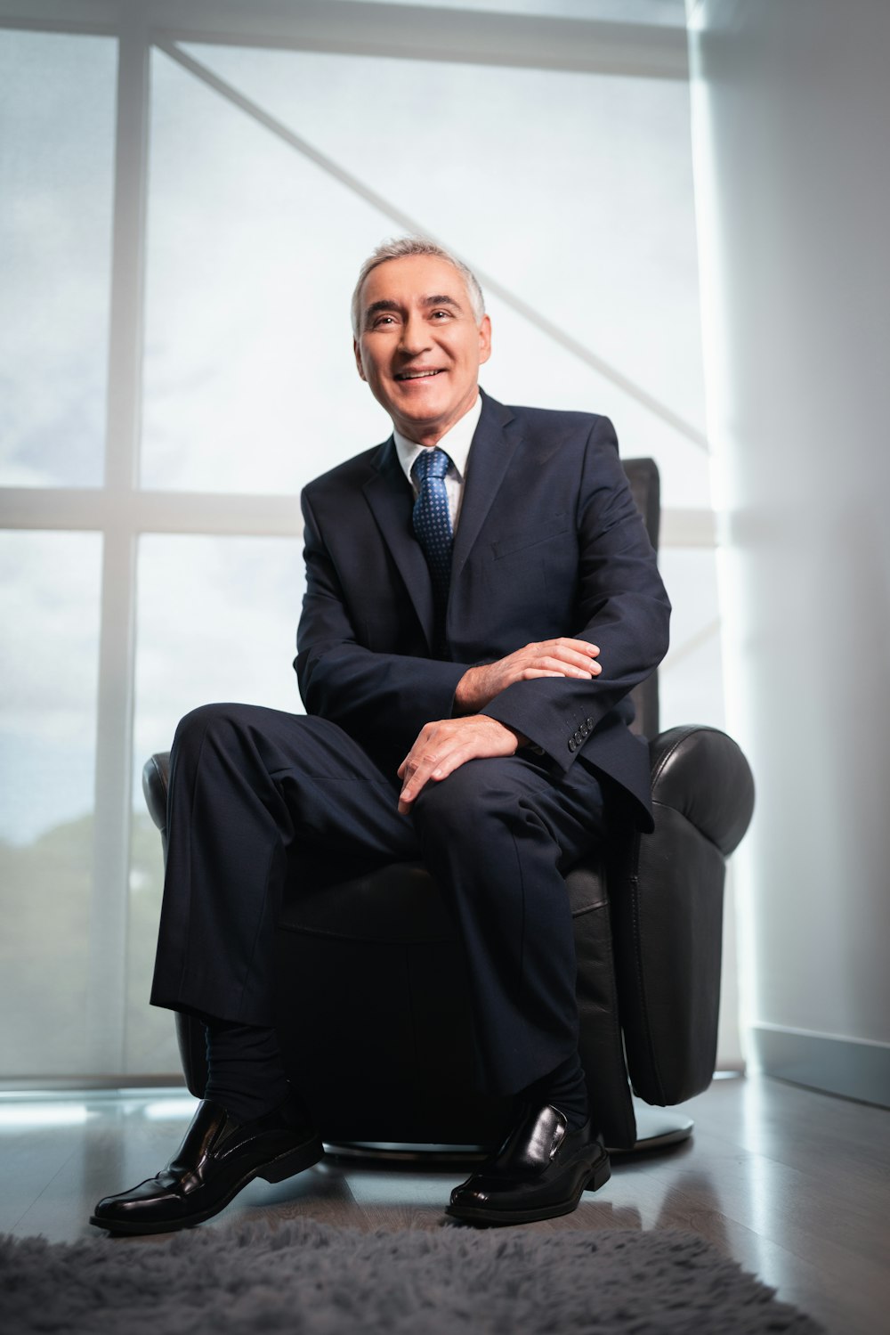 a man in a suit and tie sitting in a chair