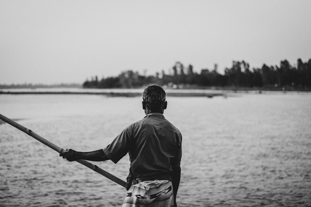 Un hombre parado en un bote mirando hacia el agua