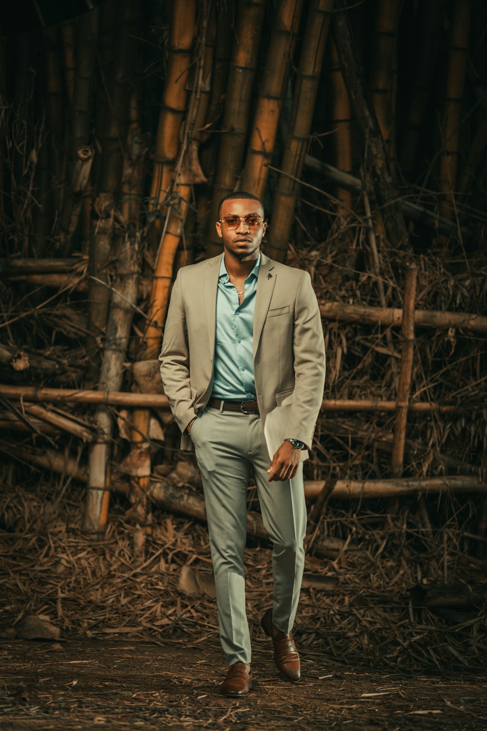 a man standing in front of a bamboo tree