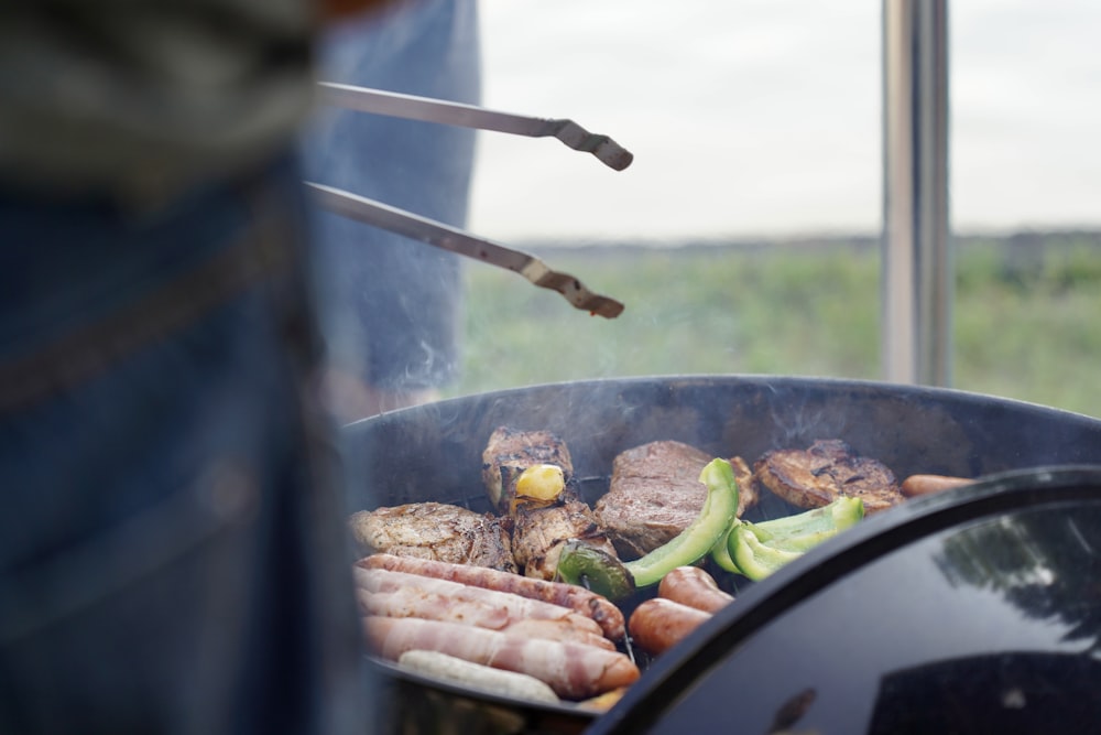 a grill with meat and vegetables cooking on it