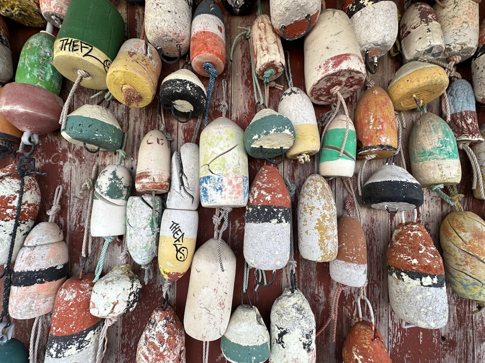 a bunch of different colored buoys hanging on a wall