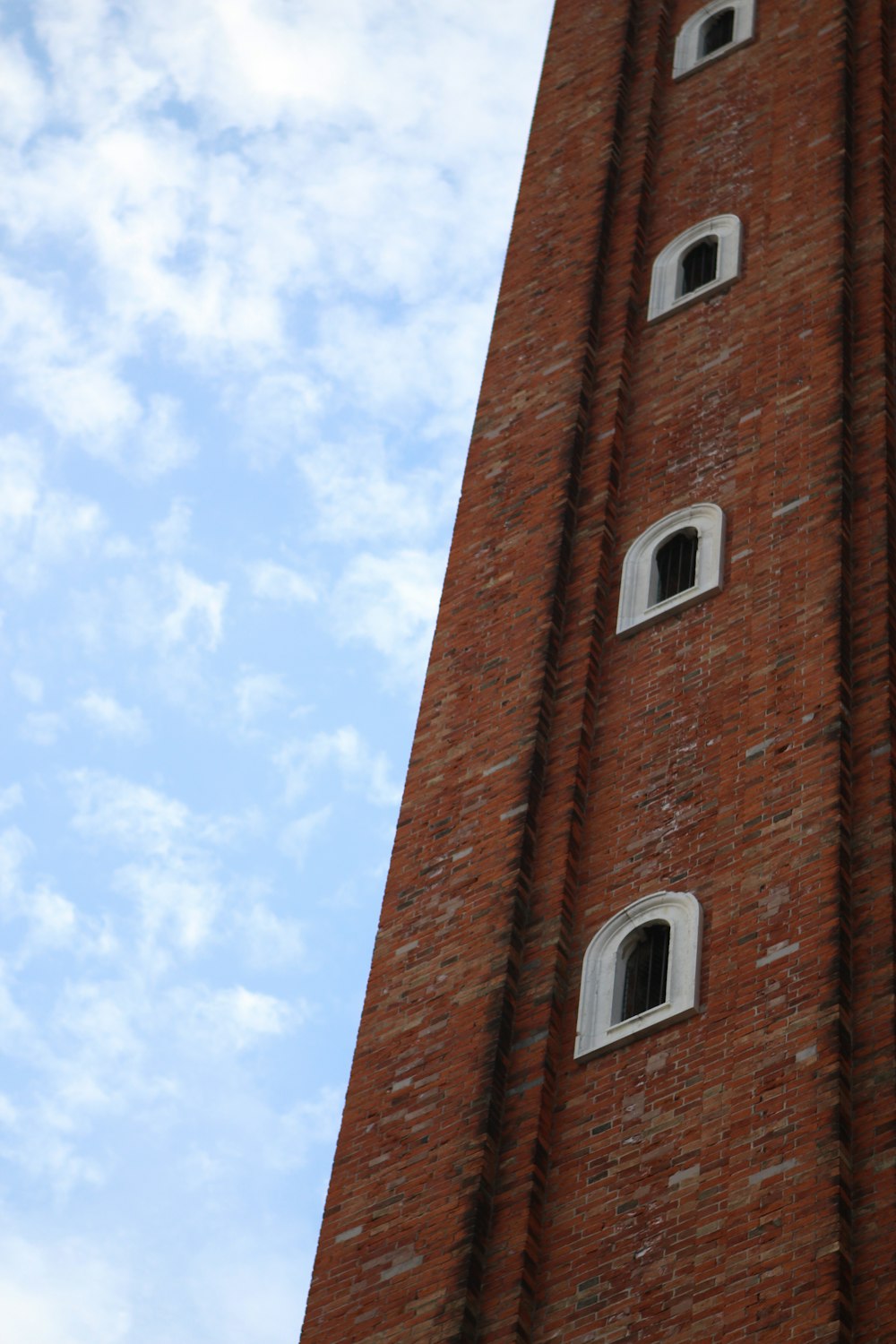 a tall brick tower with a clock on each of it's sides