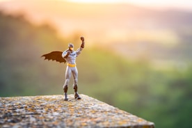 a figurine of a man with a bat on top of a rock