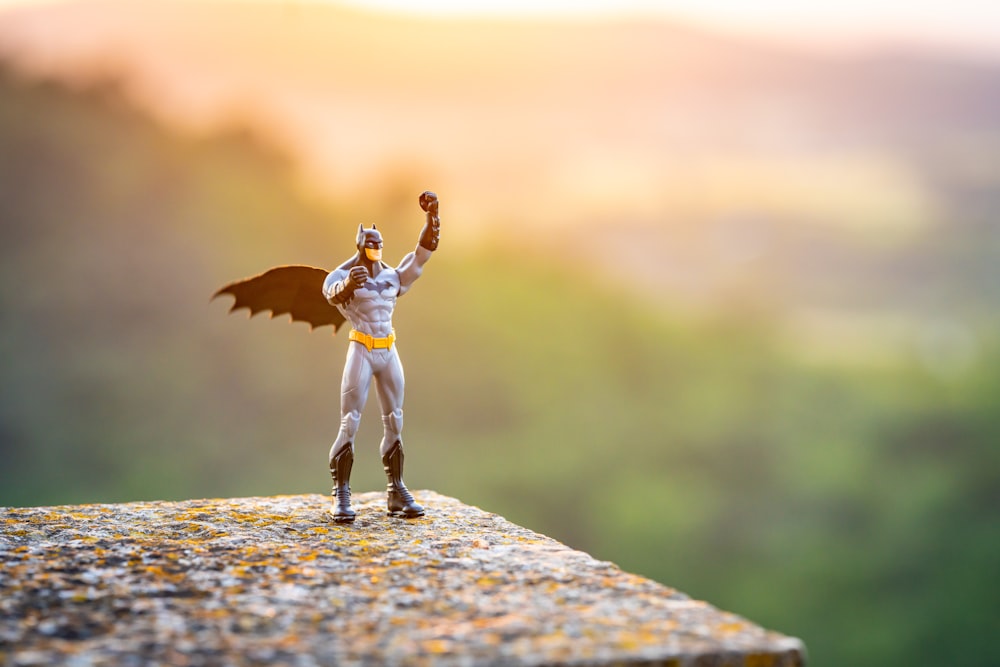 a figurine of a man with a bat on top of a rock