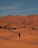 a person walking across a sandy field in the desert