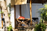 A sunny backyard scene with a comfortable camping chair and portable grill ready for a weekend cookout.