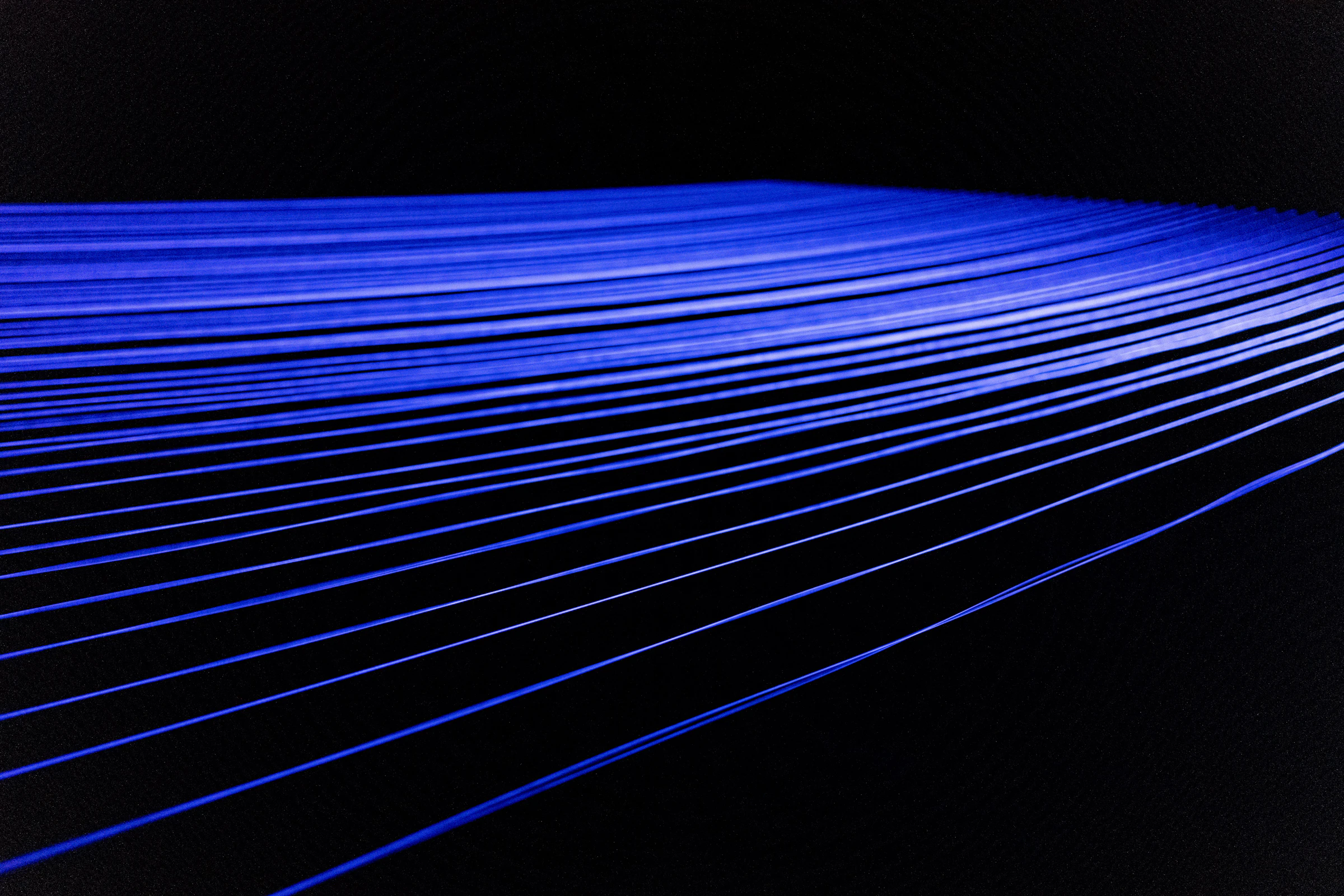 Streaks of blue light converging across a dark field