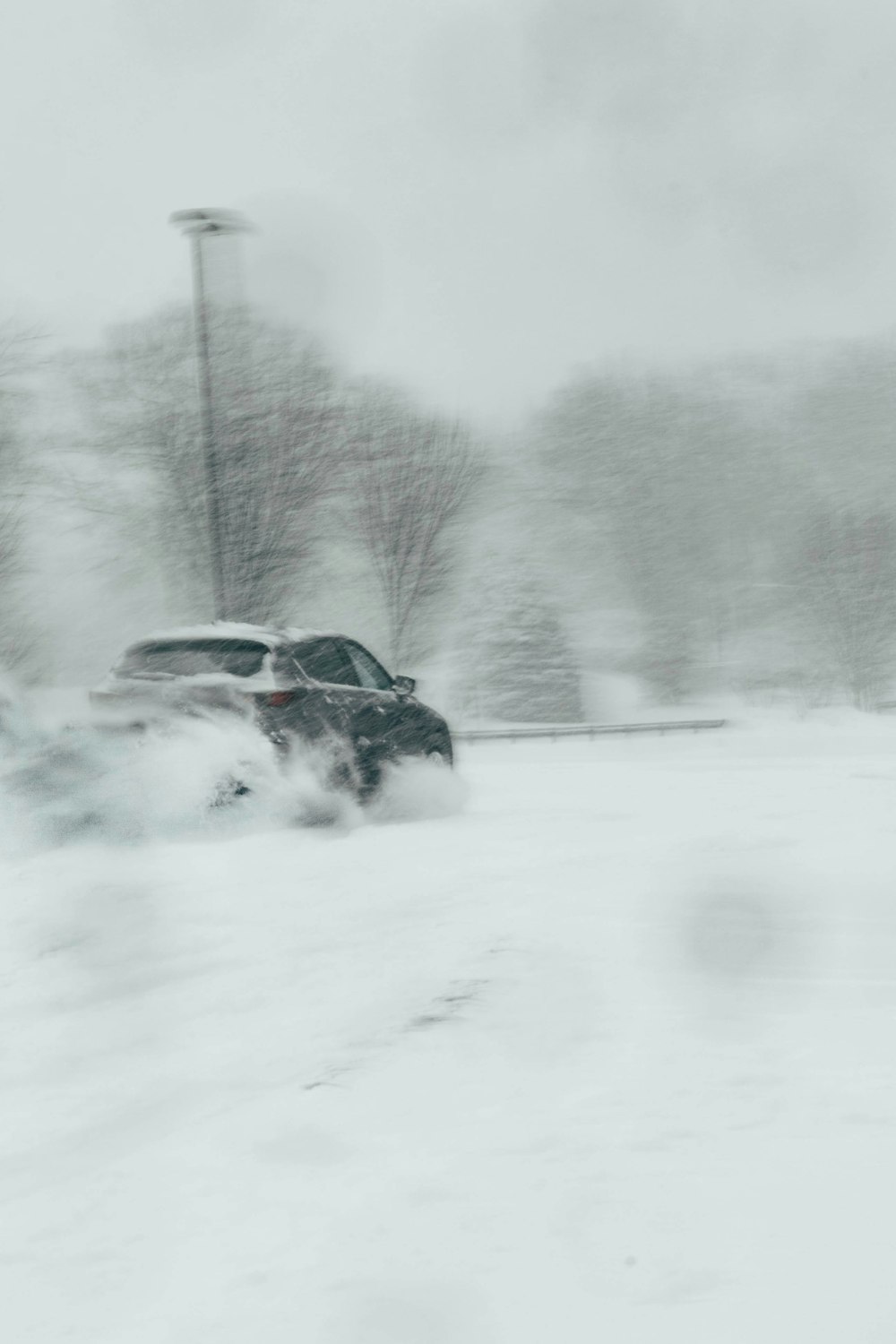 a car driving through a snow covered parking lot