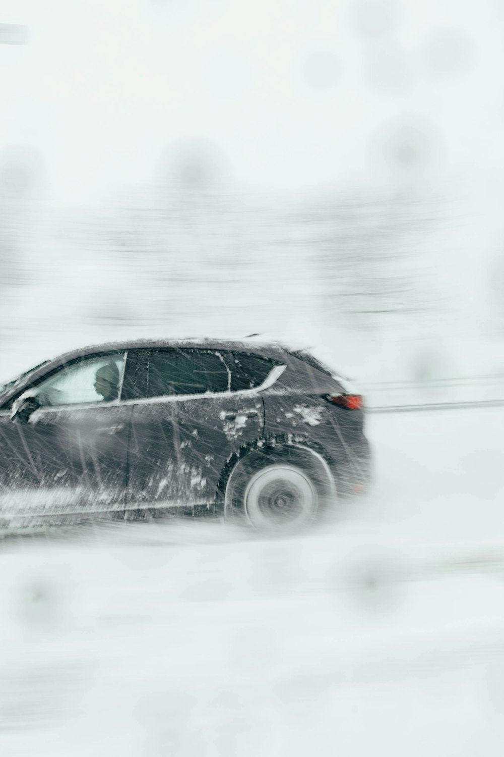 ein Auto, das eine schneebedeckte Straße hinunterfährt