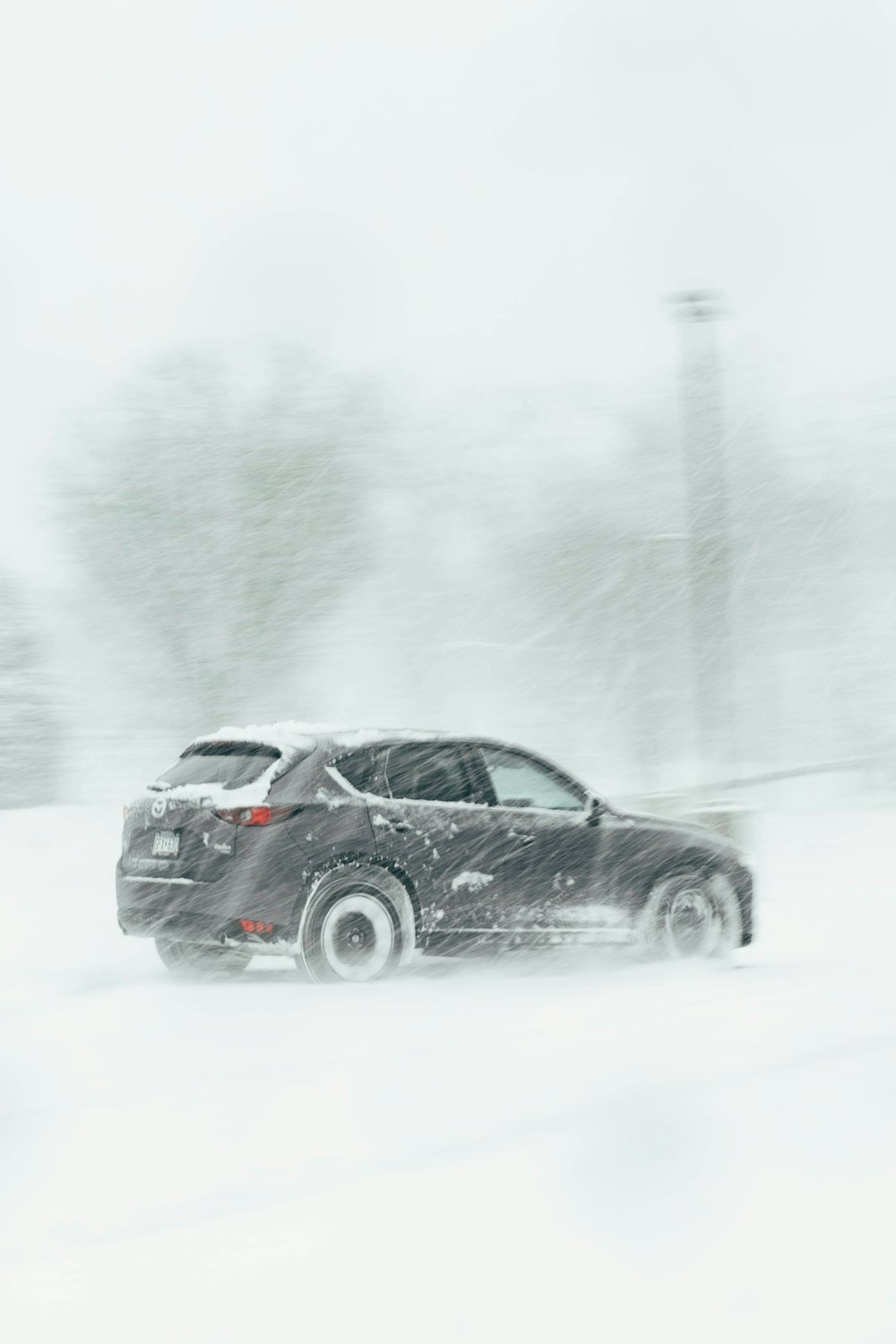 a car driving through a snow covered parking lot