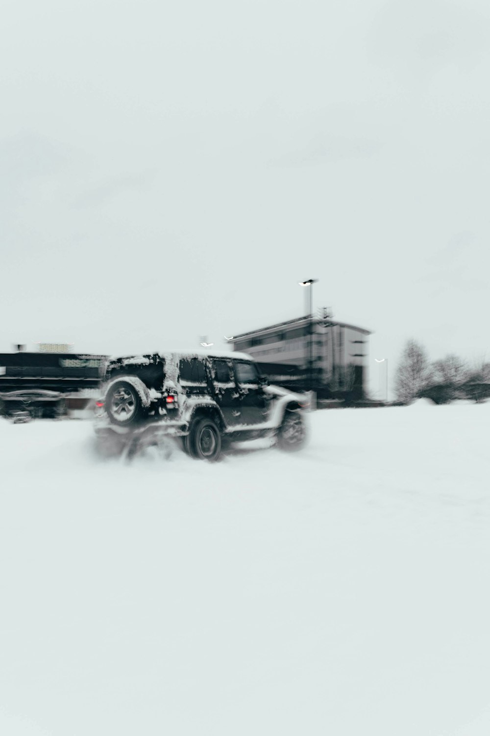 Un camión negro conduciendo por una carretera cubierta de nieve