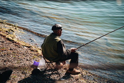 Angler seated on the bank of a UK lake during a carp fishing session