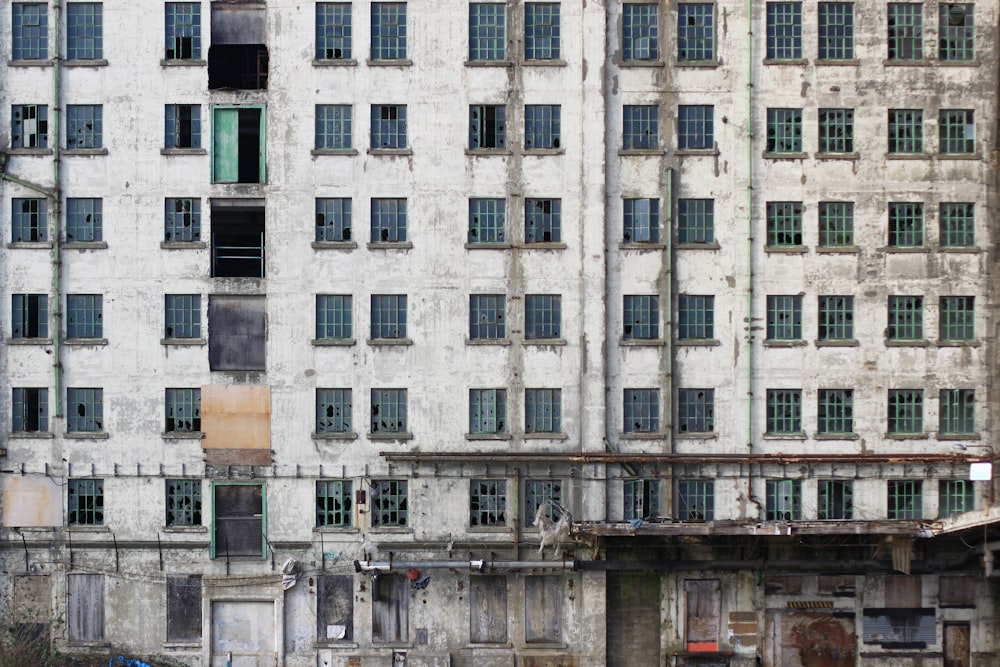 an old building with lots of windows next to a body of water