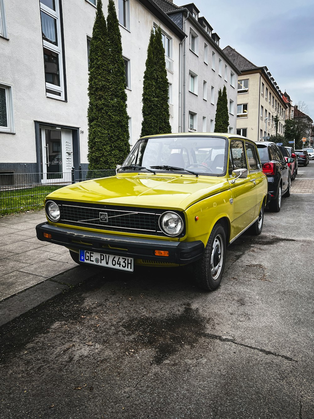 a yellow car parked on the side of the road